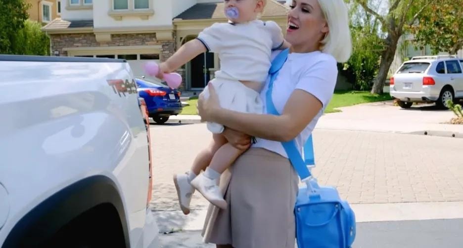 Mom carrying baby and blue Quick Pak bag